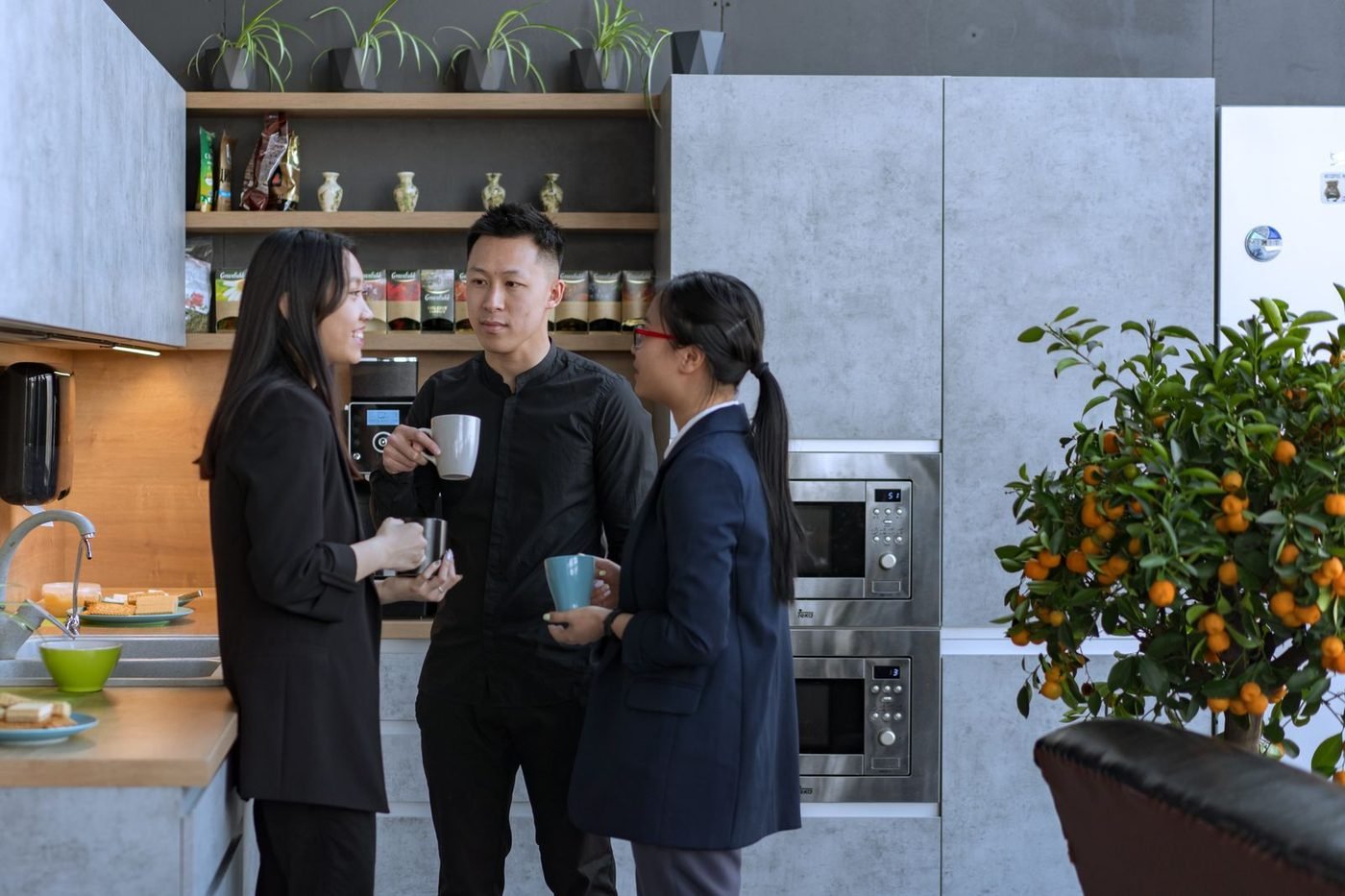 Coworkers enjoying a coffee break together in a modern office kitchen